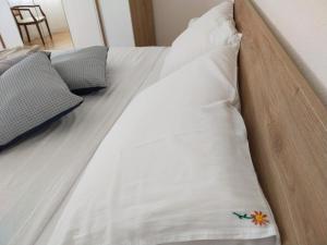 um close-up de uma cama branca com almofadas em Helianthus em Assemini