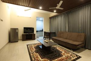 ein Wohnzimmer mit einem Sofa und einem TV in der Unterkunft Minas Manor in Tiruchchirāppalli