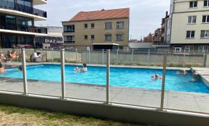 a group of people swimming in a swimming pool at luxestudio - zeezicht - groot terras - zwembad in Ostend