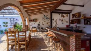 uma cozinha com um bar e cadeiras num quarto em Cortijo los Dólmenes Antequera by Ruralidays em Antequera