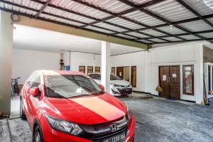 a red car is parked in a garage at RedDoorz @ Kratonan Solo in Solo