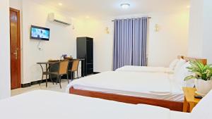 ein Hotelzimmer mit 2 Betten und einem Tisch in der Unterkunft Kampot Coco Guest House in Kampot
