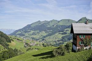 a house on the side of a hill with mountains at Apartment BergIN in Raggal