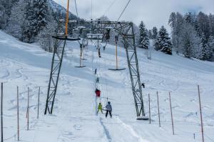 een groep mensen op een skilift in de sneeuw bij Apartment BergIN in Raggal