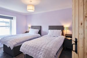 - 2 lits dans une chambre avec 2 lampes et une fenêtre dans l'établissement Min Yr Afon- Central cosy Cottage, walk to restaurants and Castle, à Laugharne