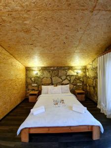 ein Schlafzimmer mit einem großen Bett in einer Steinmauer in der Unterkunft Guest house Ijevan's Garden in Idschewan
