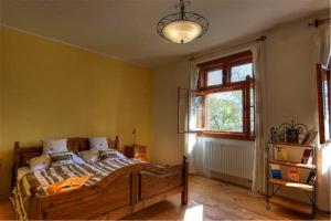 ein Schlafzimmer mit einem Holzbett und einem Fenster in der Unterkunft Keresztkúti Erdei Pihenőhely in Kőszeg