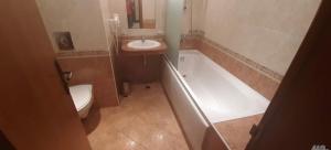 a bathroom with a sink and a tub and a toilet at Sunset Resort Apartament C3 - 22 in Pomorie +9 photos