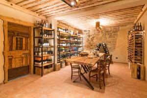 Velo Veronese的住宿－13 Comuni Ristorante E Albergo，用餐室配有桌子和酒瓶架