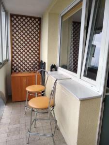 two chairs and a counter in a room with a window at Apartament z widokiem na Zatokę, Hel, Port i lasy in Gdańsk