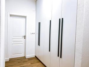 einen Flur mit weißen Schränken und einer weißen Tür in der Unterkunft Luxury apartment Struga in Struga