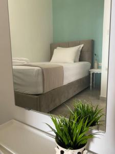 1 dormitorio con 1 cama con espejo y 2 plantas en Seaside Apartment in Glyfada-Trizonia, en Glyfada Fokidas