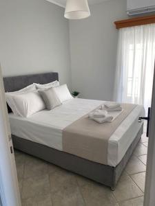 a bedroom with a large bed with white sheets and pillows at Seaside Apartment in Glyfada-Trizonia in Glyfada Fokidas