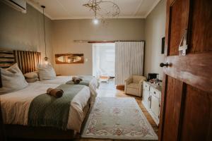 a bedroom with two beds and a chair in it at three birds country house in Richmond
