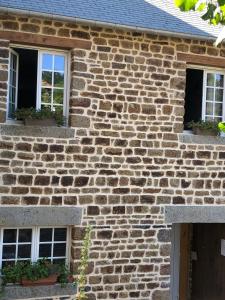une maison en briques avec deux fenêtres et une porte dans l'établissement "La chambre des TISSERANDS", à Ménil-Hubert-sur-Orne