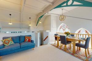 a living room with a blue couch and a table at Church Mews in Exmouth +6 photos