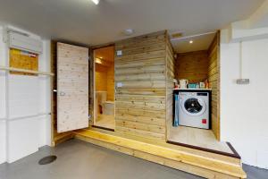 a washer and dryer in a bathroom with wooden walls at Church Mews in Exmouth