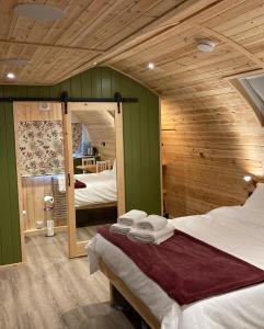 um quarto com duas camas e um espelho em Bedrule Old Manse Glamping em Hawick