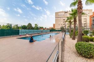 a swimming pool with people sitting in the water at Moderno apartamento con Piscina y Parking in Granada