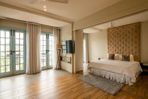 a bedroom with a large bed and a flat screen tv at Villa Donna in Dona Paula