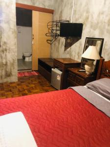 a bedroom with a bed and a bathroom with a toilet at Bee Friend Hostel in Chiang Mai