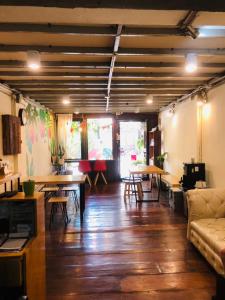 a living room with wooden floors and tables and a couch at Bee Friend Hostel in Chiang Mai