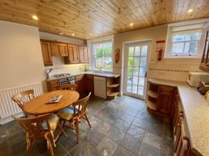 eine Küche mit einer Holzdecke sowie einem Tisch und Stühlen in der Unterkunft Cosy 2-Bed House in the Heart of Keswick in Keswick