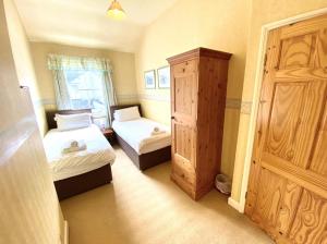 ein kleines Schlafzimmer mit 2 Betten und einem Schrank in der Unterkunft Cosy 2-Bed House in the Heart of Keswick in Keswick