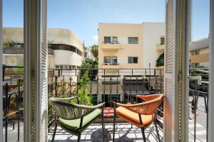 a balcony with chairs and a view of a building at Alberto by Isrotel Design in Tel Aviv