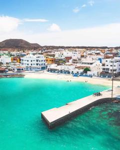 widok na plażę z budynkami i wodą w obiekcie Casa M de mar - Dúplex con vistas w Corralejo
