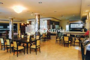 - une salle à manger avec une table et des chaises dans l'établissement Hotel Yasmin Makassar Mitra RedDoorz, à Makassar