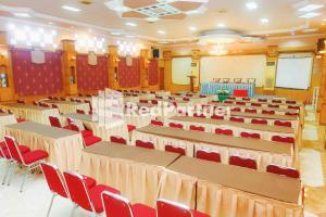 une salle de conférences avec des tables et des chaises rouges dans l'établissement Hotel Yasmin Makassar Mitra RedDoorz, à Makassar
