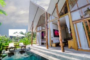 a villa with a swimming pool and a house at Satya Boutique Resort & Spa in Havelock Island