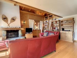 a living room with red chairs and a fireplace at Sovereu 124 in Verbier