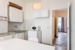 uma cozinha com armários brancos e uma bancada em Appartamento Galgani - Affitti Brevi Italia em Lucca