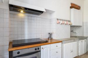 uma cozinha com armários brancos e um fogão em Appartamento Galgani - Affitti Brevi Italia em Lucca