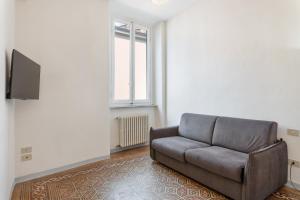 uma sala de estar com um sofá e uma televisão de ecrã plano em Appartamento Galgani - Affitti Brevi Italia em Lucca