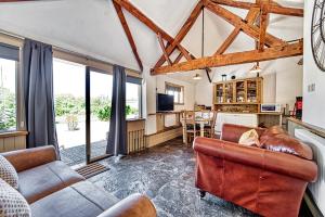 a living room with a couch and a table at Guest Homes - Snodsbury Barn in Upton Snodsbury