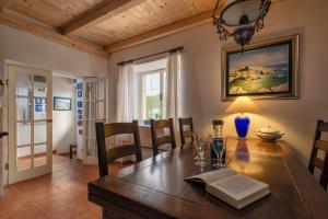 a dining room with a wooden table with chairs and a painting at Villa Cincilograd in Jelsa