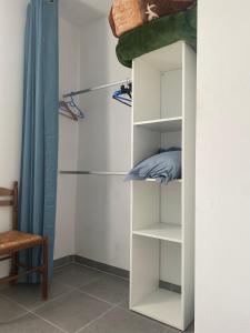un armario con estanterías blancas y una cortina azul en Chambres d'hôtes Drome en Chatuzange-le-Goubet