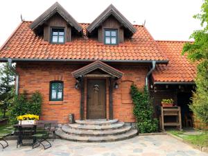 a red brick house with a door and stairs at Czerwony domek nad samym jeziorem in Mikołajki +18 photos