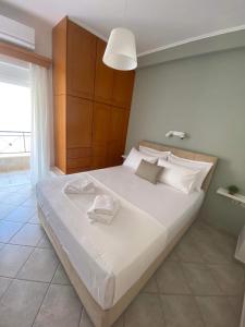 a bedroom with a large bed with two towels on it at Seaside Apartment in Glyfada-Trizonia in Glyfada Fokidas