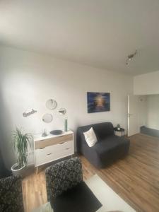 sala de estar con sofá y silla en Ferienwohnung Robbe, en Wilhelmshaven