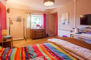una camera da letto con un letto con una coperta colorata di Kerouidret a Penvénan
