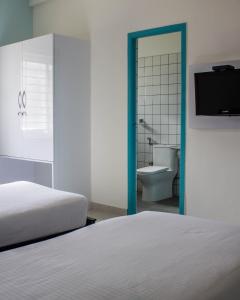 - une chambre avec un lit et une salle de bains avec des toilettes dans l'établissement Catalyst Suites, à Bangalore