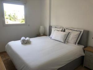a bedroom with a large white bed with shoes on it at Citronnier Monaco Sea View in Beausoleil
