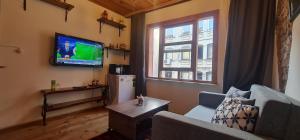 a living room with a couch and a tv on the wall at Galata Duplex Apt. *Balcony* 1 min to Metro Stn. in Istanbul