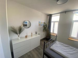 a bedroom with a bed and a dresser and a mirror at FeWo Jade in Wilhelmshaven