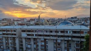 a view of a city at sunset with a building at Risto Apartment in Skopje