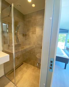 a shower with a glass door in a bathroom at Hages Badehotel in Rødby